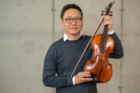 Das Bild zeigt den Musikschullehrer Kyunghwan Bai mit einer Violine.