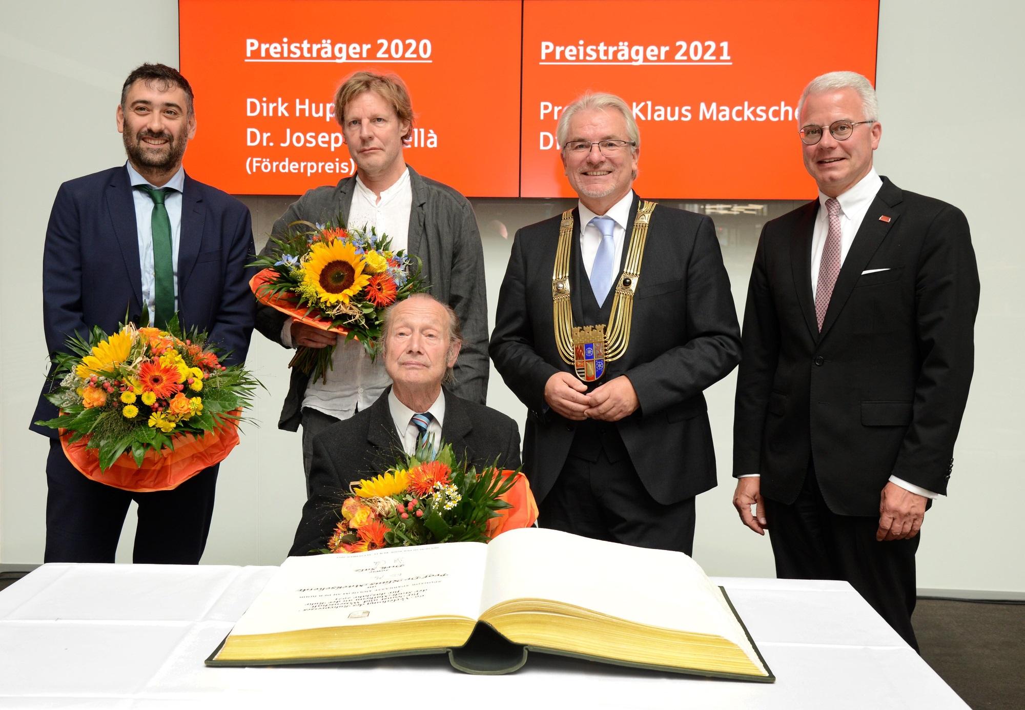 Die Preisträger des Ruhrpreises für Kunst und Wissenschaft der Jahre 2020 und 2021 mit dem Oberbürgermeister und dem Vorstandsvorsitzenden der Sparkasse vor dem Goldenen Buch