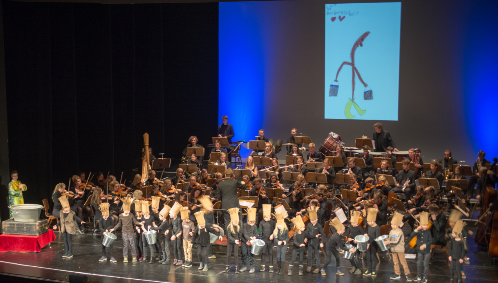 Der Zauberlehrling | Familienkonzert im Jahr 2018 Das Bild zeigt Schüler*innen der Hölterschule, die am 25.11.2018 im Rahmen der Familienkonzerte in der Stadthalle den ZAUBERLEHRLING aufgeführt haben.