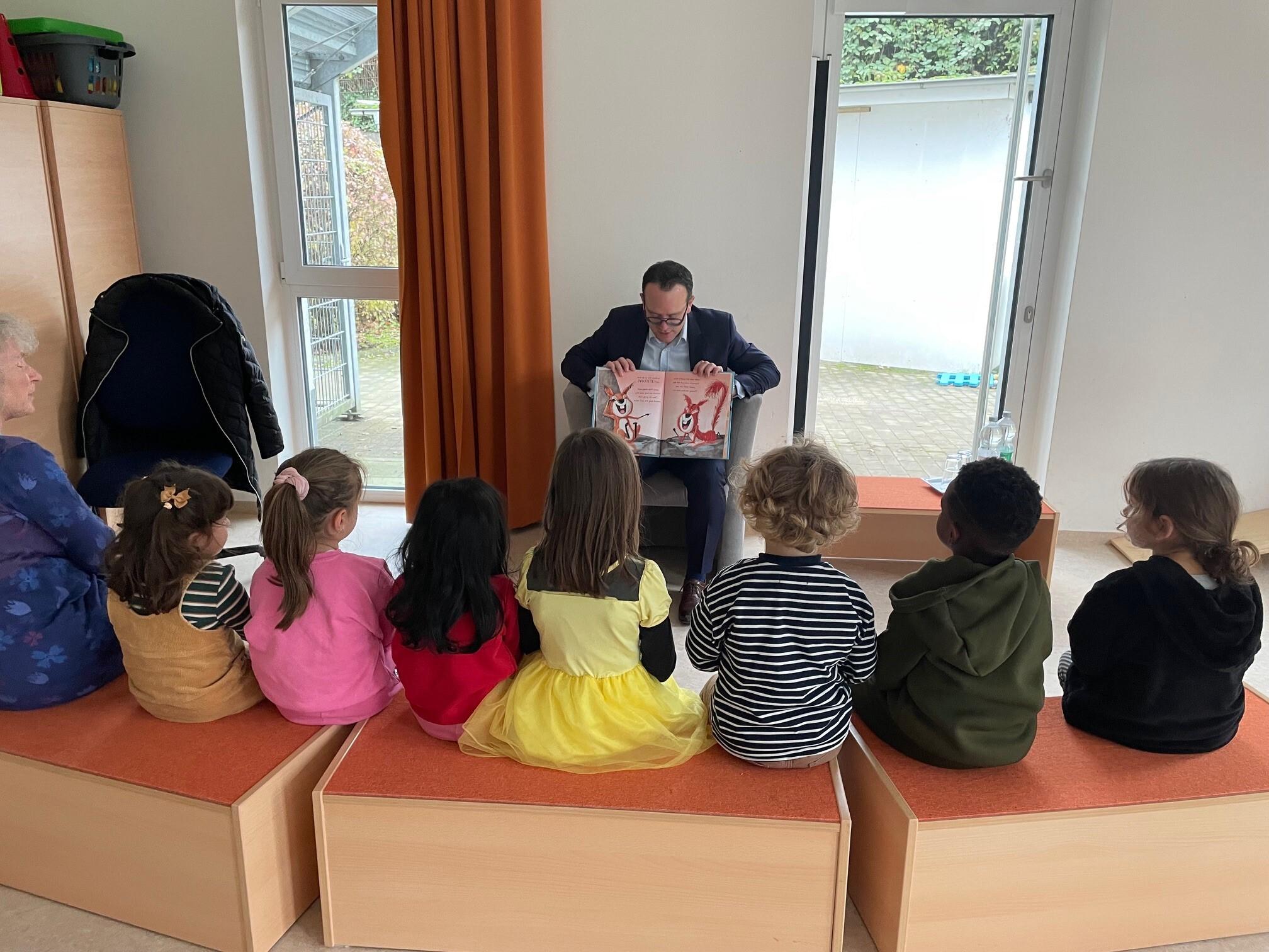 Herr Lüngen liest Kindern ein Buch vor.