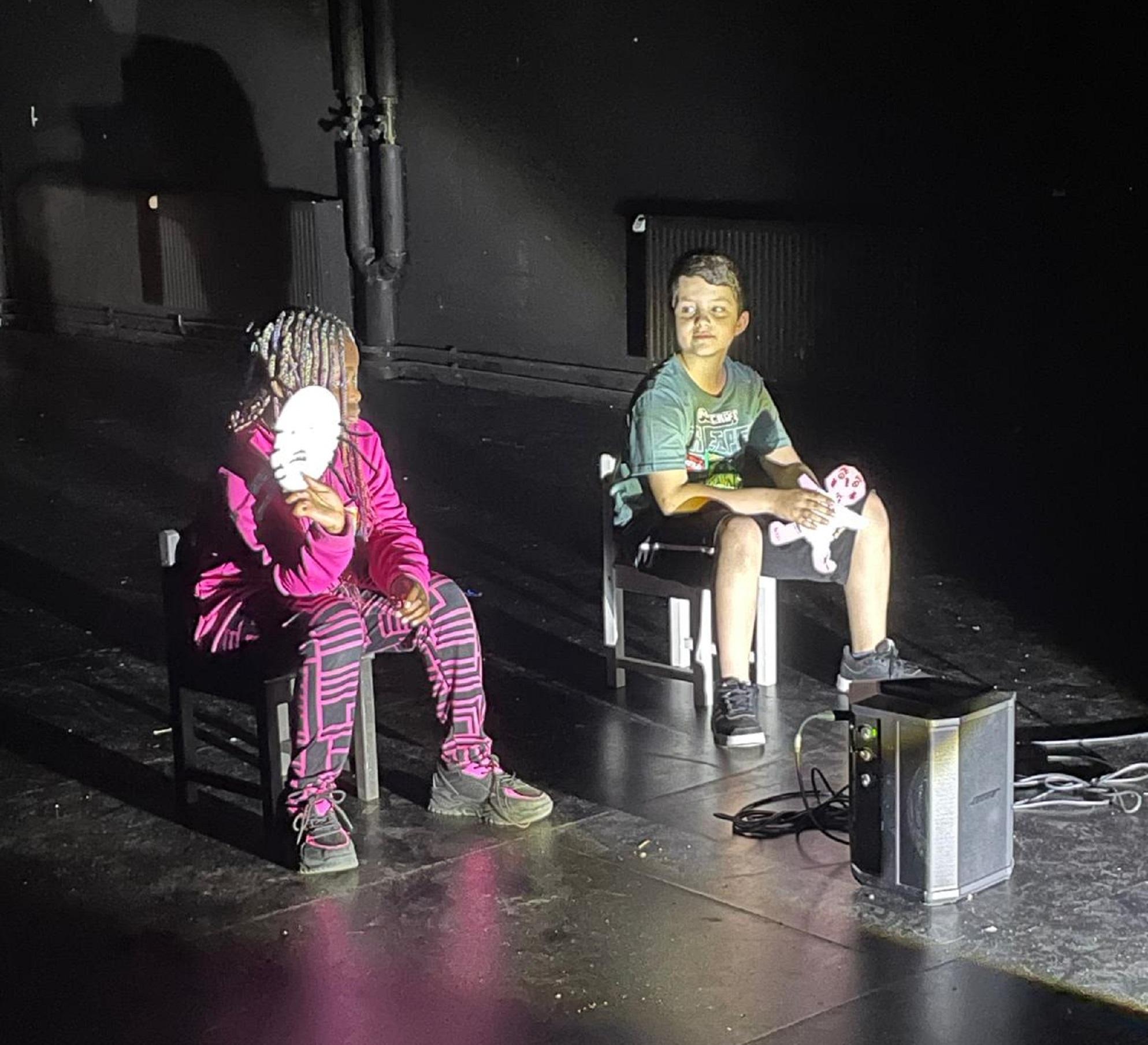 Kinder präsentieren ihre Masken auf der Bühne im Theater an der Ruhr.