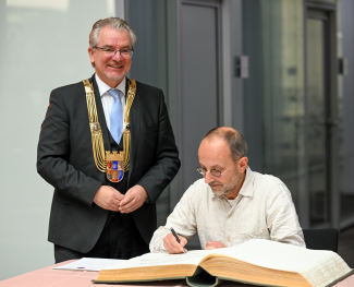 Der Künstler Alexander Voß hat den Ruhrpreis für Kunst und Wissenschaft 2022 erhalten und trägt sich ins Goldene Buch der Stadt Mülheim an der Ruhr ein.