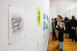 Ausstellungssituation, Mutter mit Tochter schauen Kunst an.