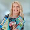 Autorin Sabine Zett, Mülheimer Kinderliteraturtage 2022 Auf dem Bild sieht man die Autorin Sabine Zett. In den Händen hält sie drei ihrer Werke.
